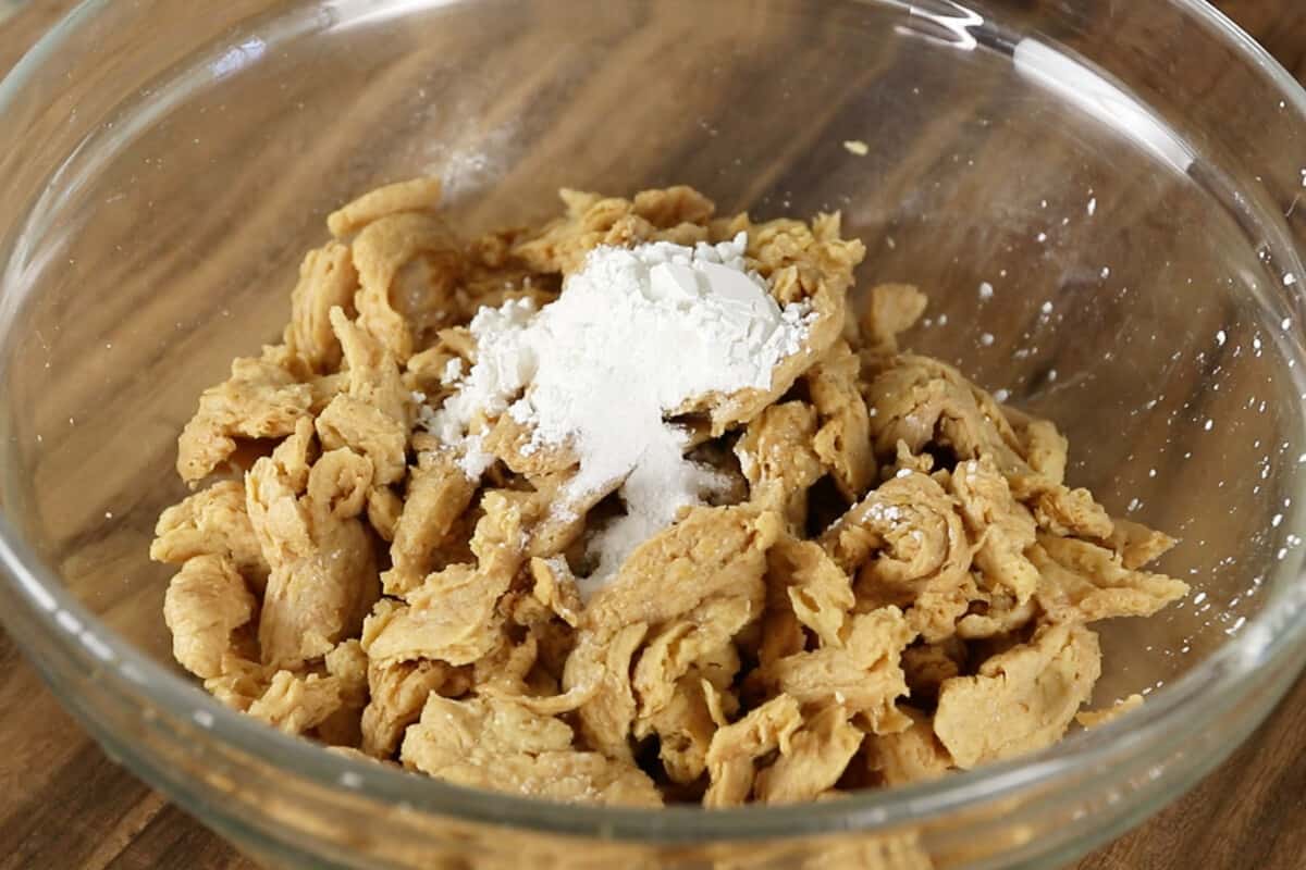 step by step - flour being added to soy curls in a bowl