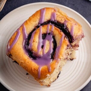 ube purple cinnamon roll on white plate