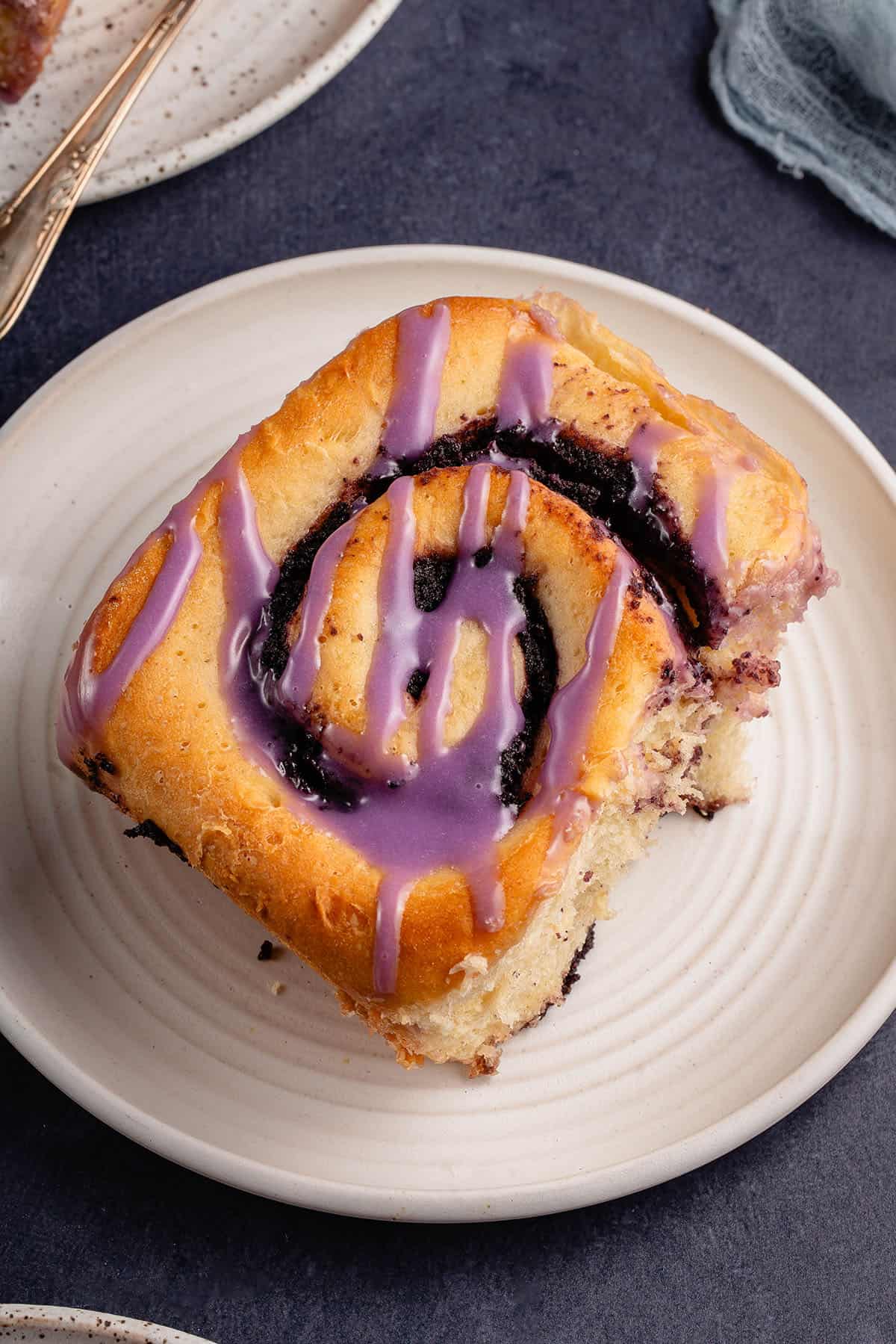 ube purple cinnamon roll on white plate