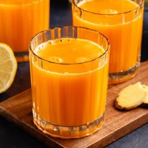 glass cups of antioxidant rich immunity juice on blue table