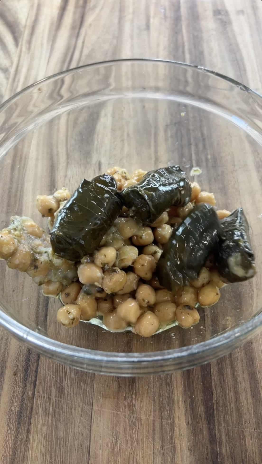 dolmas being added to the bowl of chickpeas