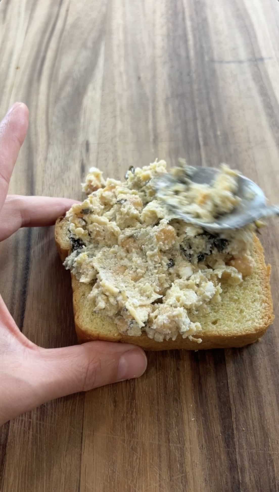 spreading the chickpea mixture on a slice of bread