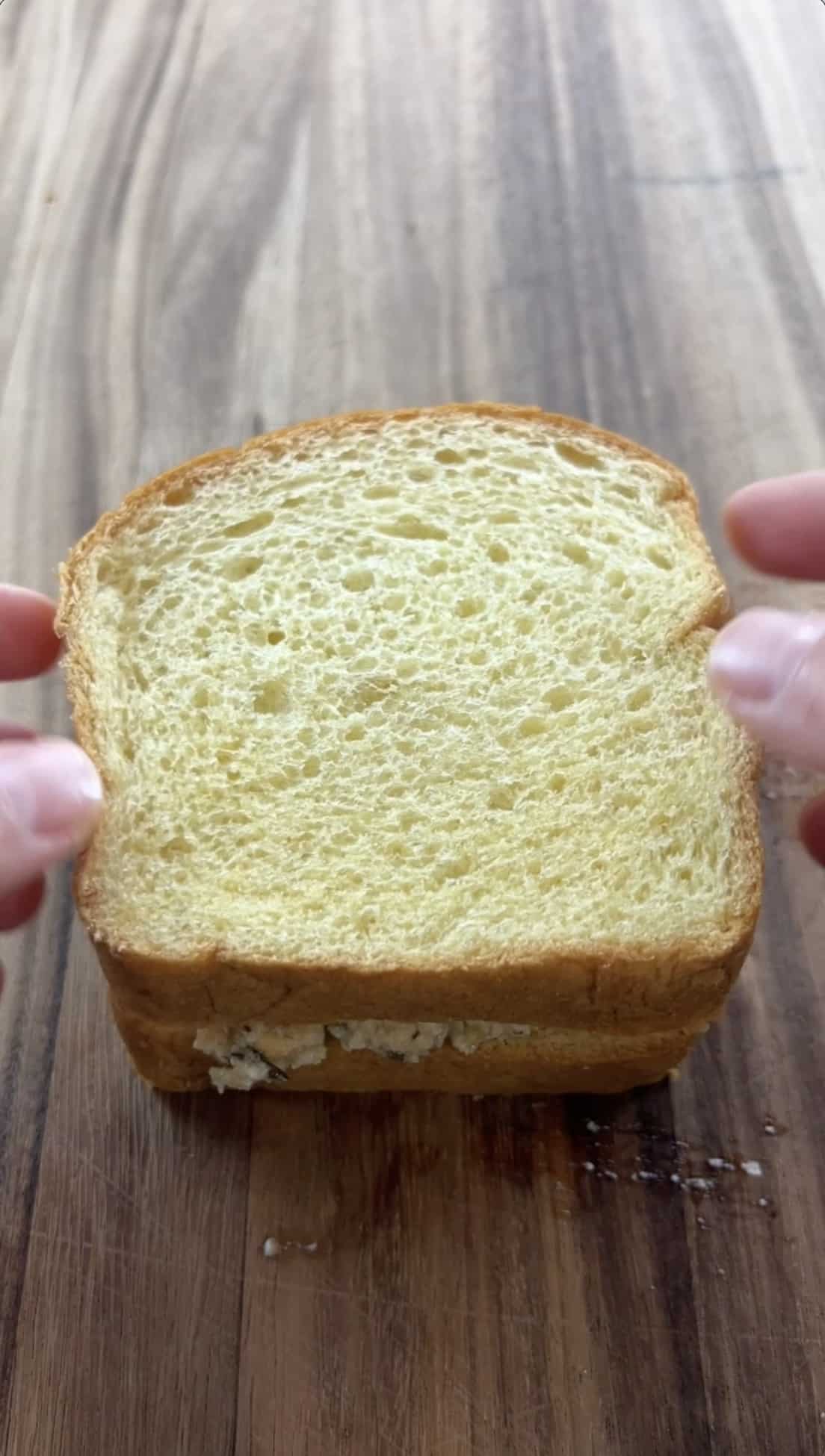 placing another slice of bread on top of the chickpea mixture to make a sandwich