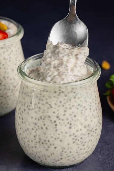 scooping Vegan Chia Pudding with Yogurt from glass jar with a spoon