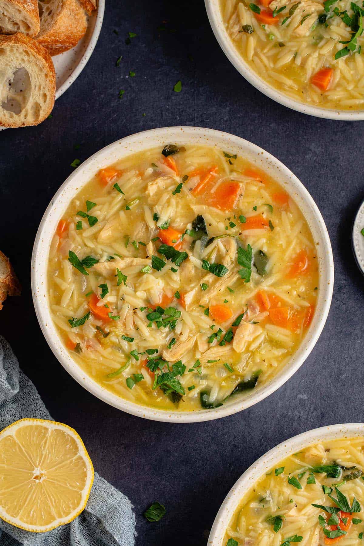 lemon chicken orzo soup in white bowl on blue table