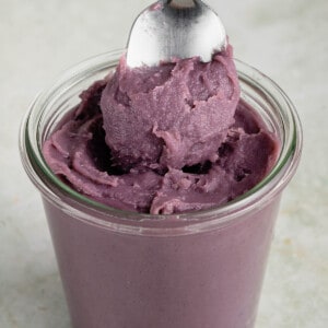 close up photo scooping out homemade ube halaya (filipino purple yam jam) from glass jar