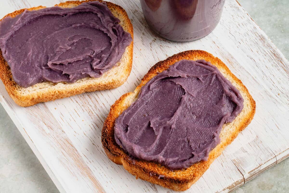 horizontal photo of toasted bread with close up photo of a piece of toast with ube halaya (filipino purple yam jam) on white board