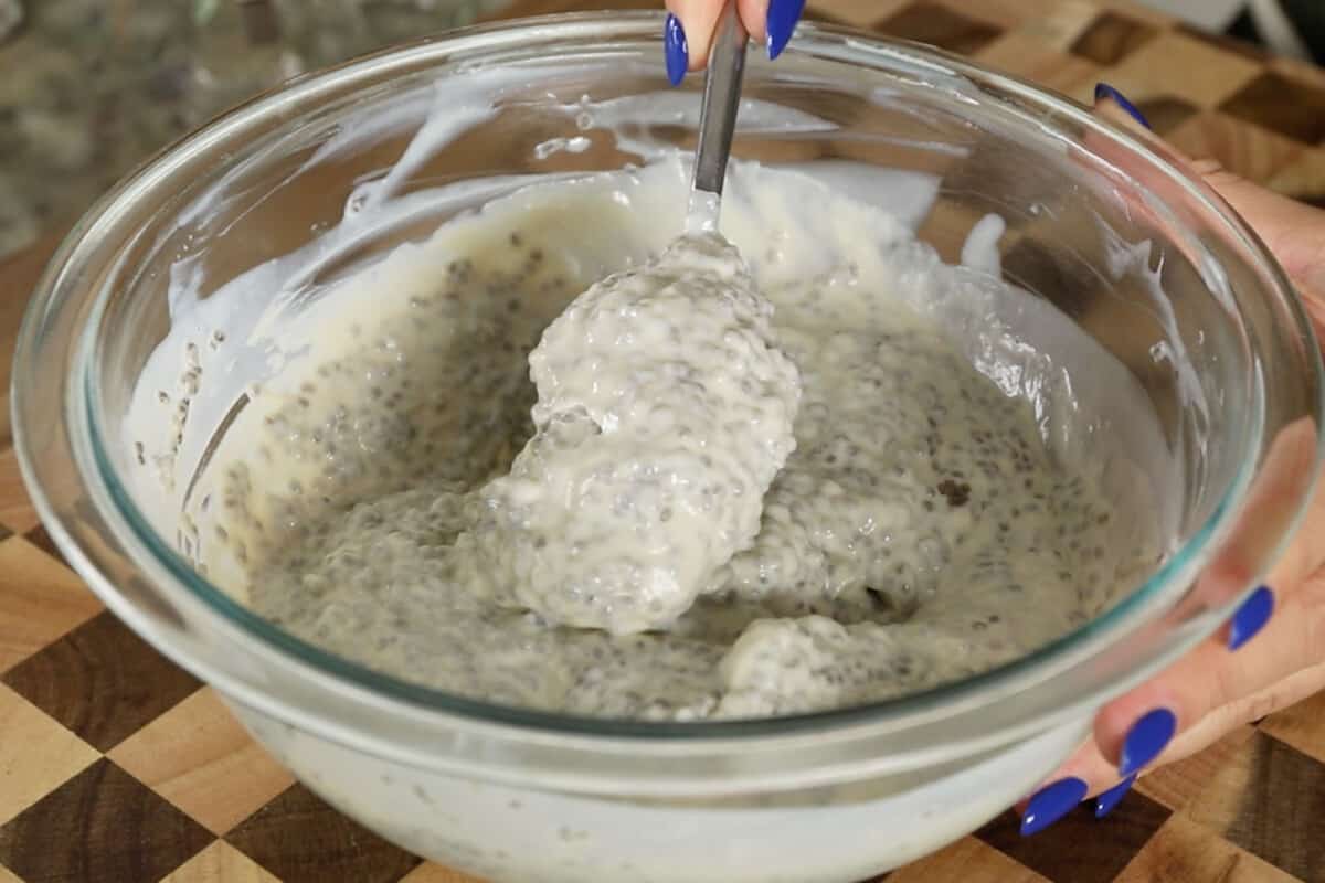 making vegan chia seed pudding with yogurt in large glass bowl