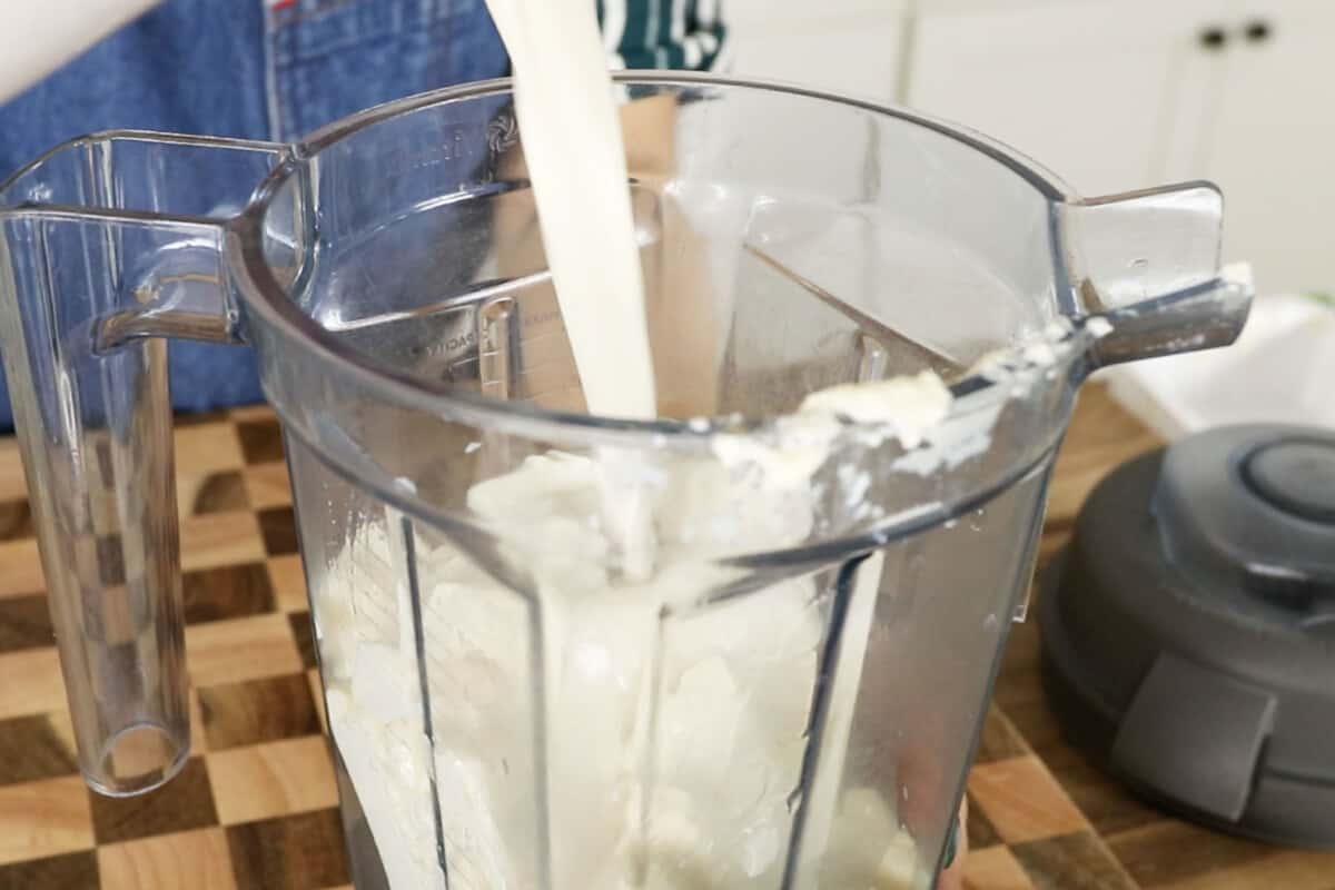 milk being poured into a blender