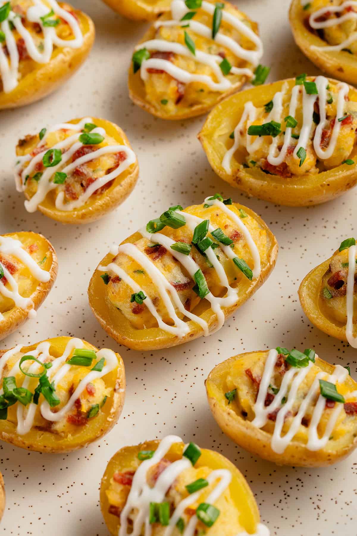 a bunch of mini twice baked potatoes on a white tray