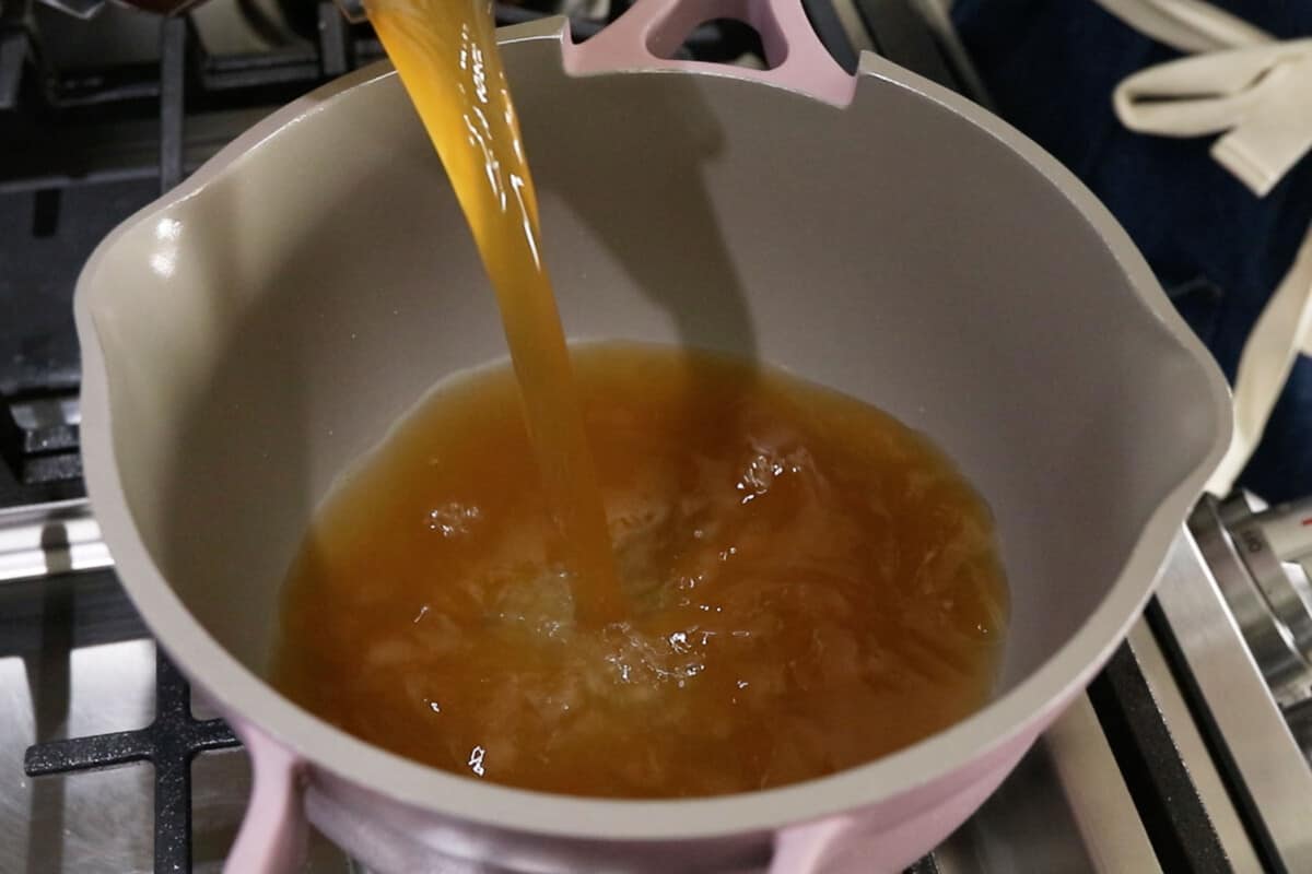 broth being poured into a pot
