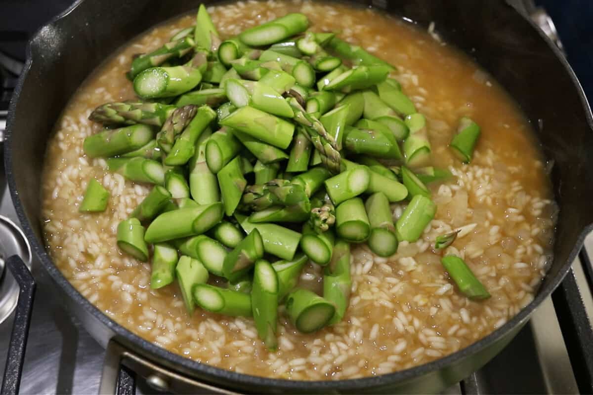 asparagus being added into the pot of risotto