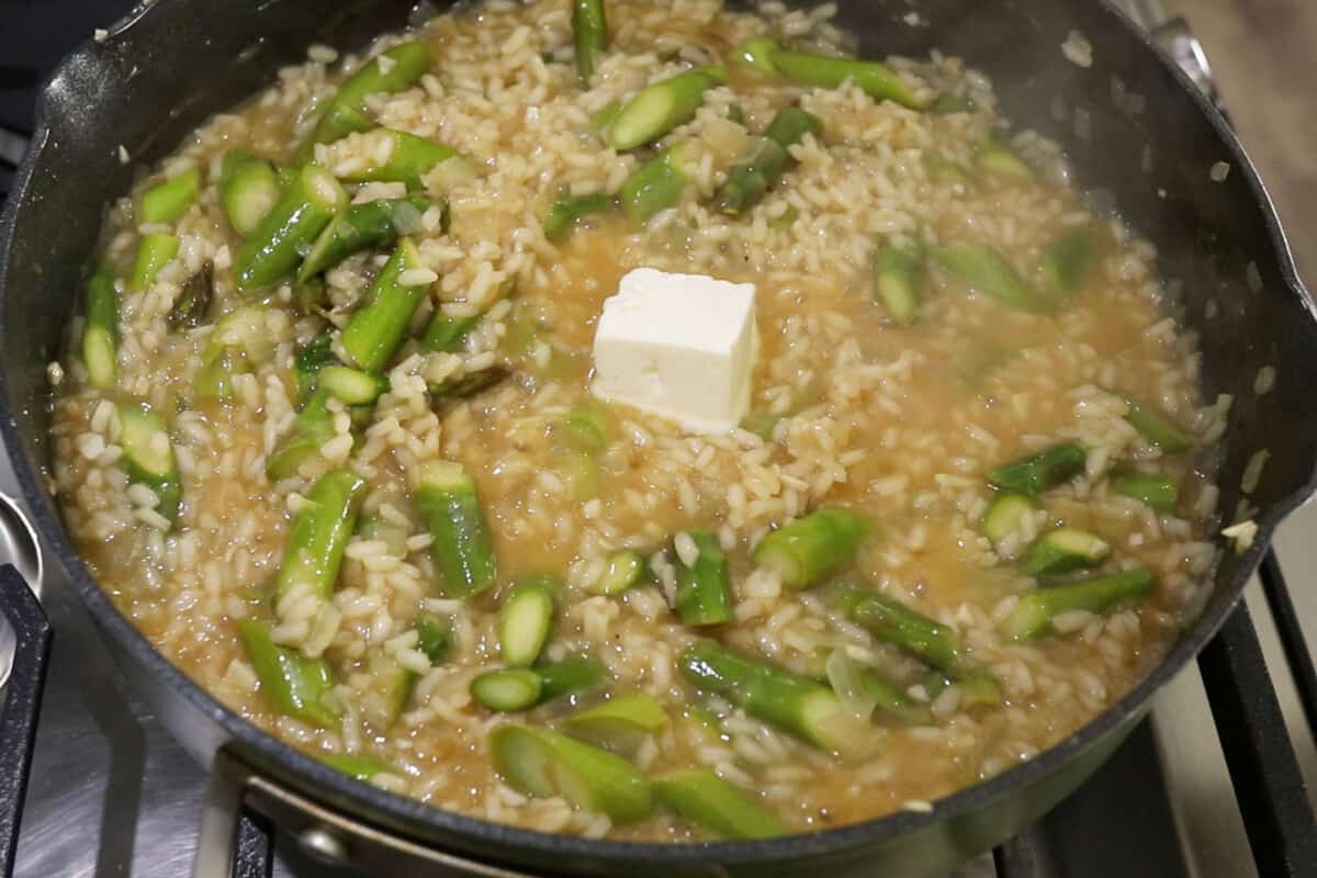 vegan butter being added to the pot of risotto