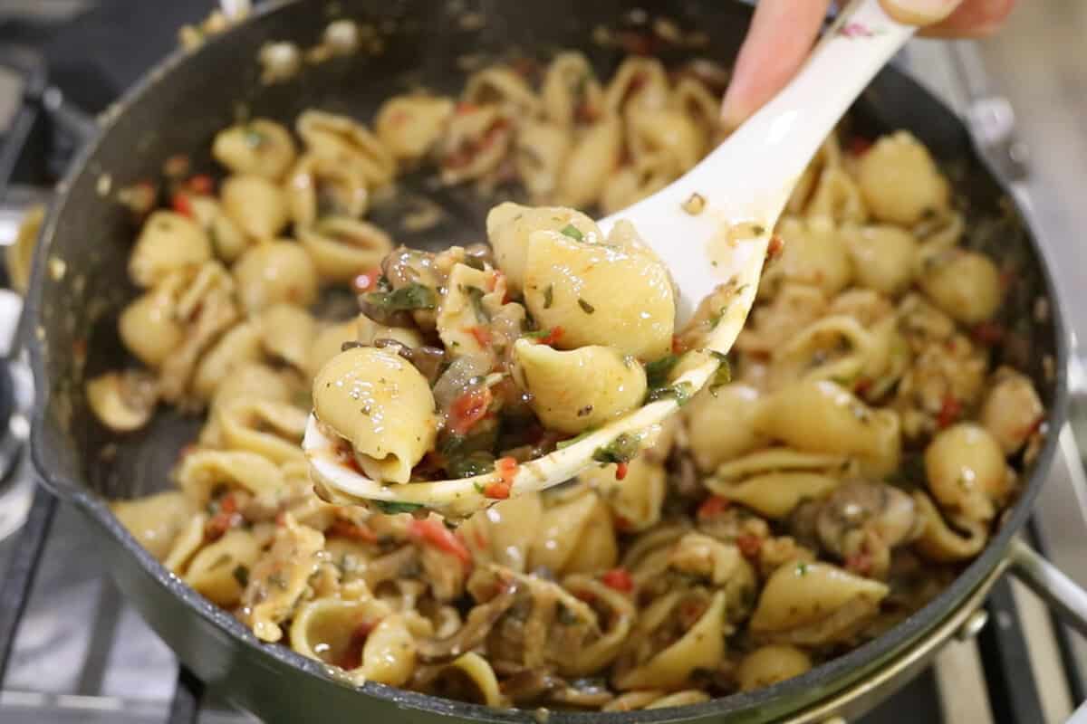 step by step spoon full of cooled vegan tuscan chicken pasta