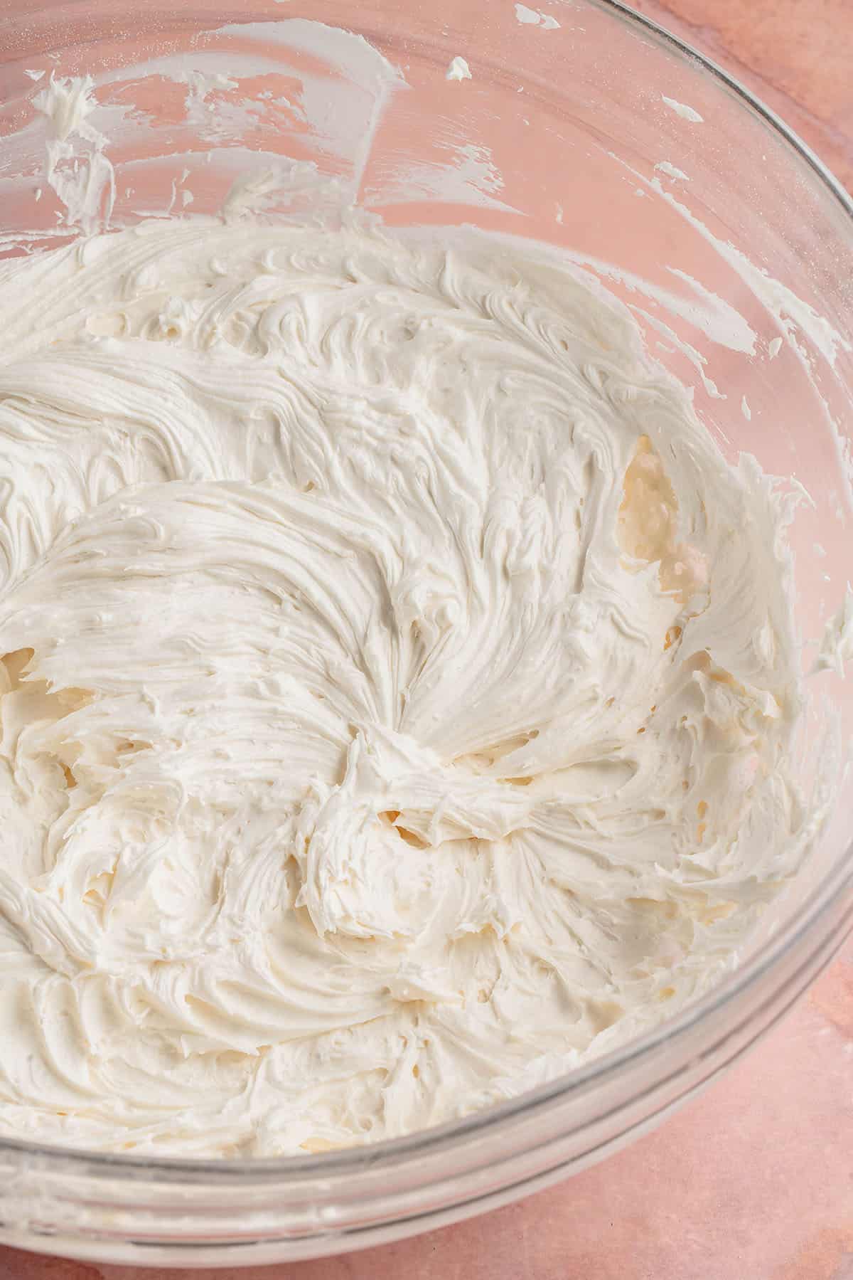 whipped buttercream frosting in large glass bowl
