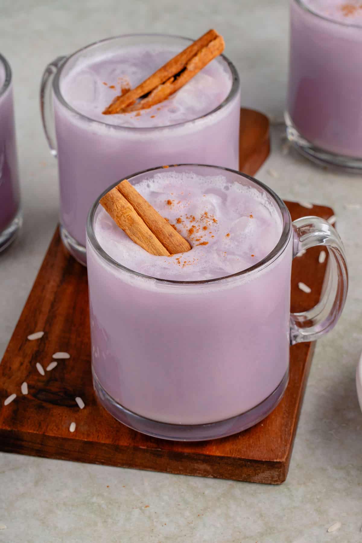 close up photo of 4 glasses of ube horchata styled on wooden cutting board