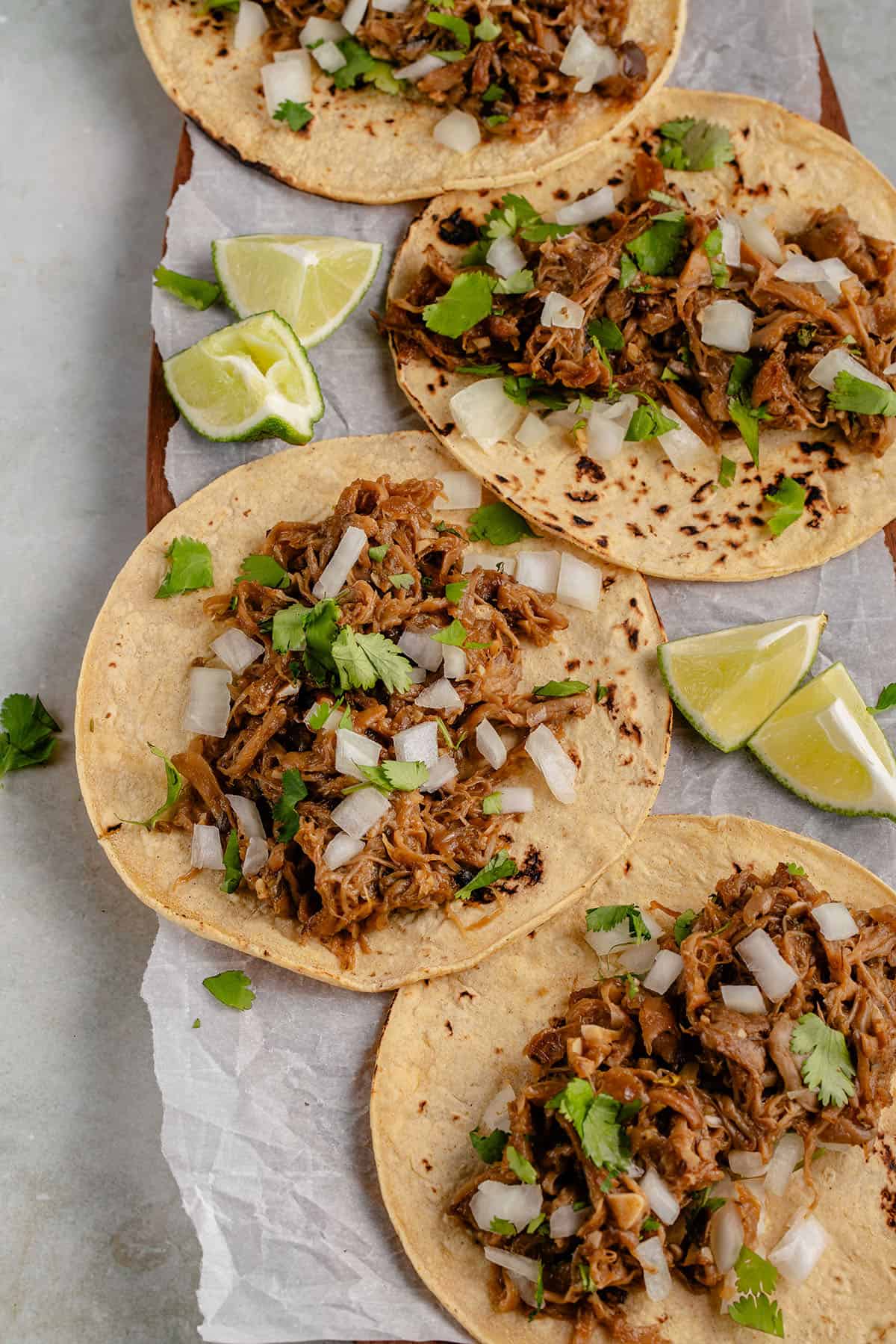 carnitas tacos in platter with limes