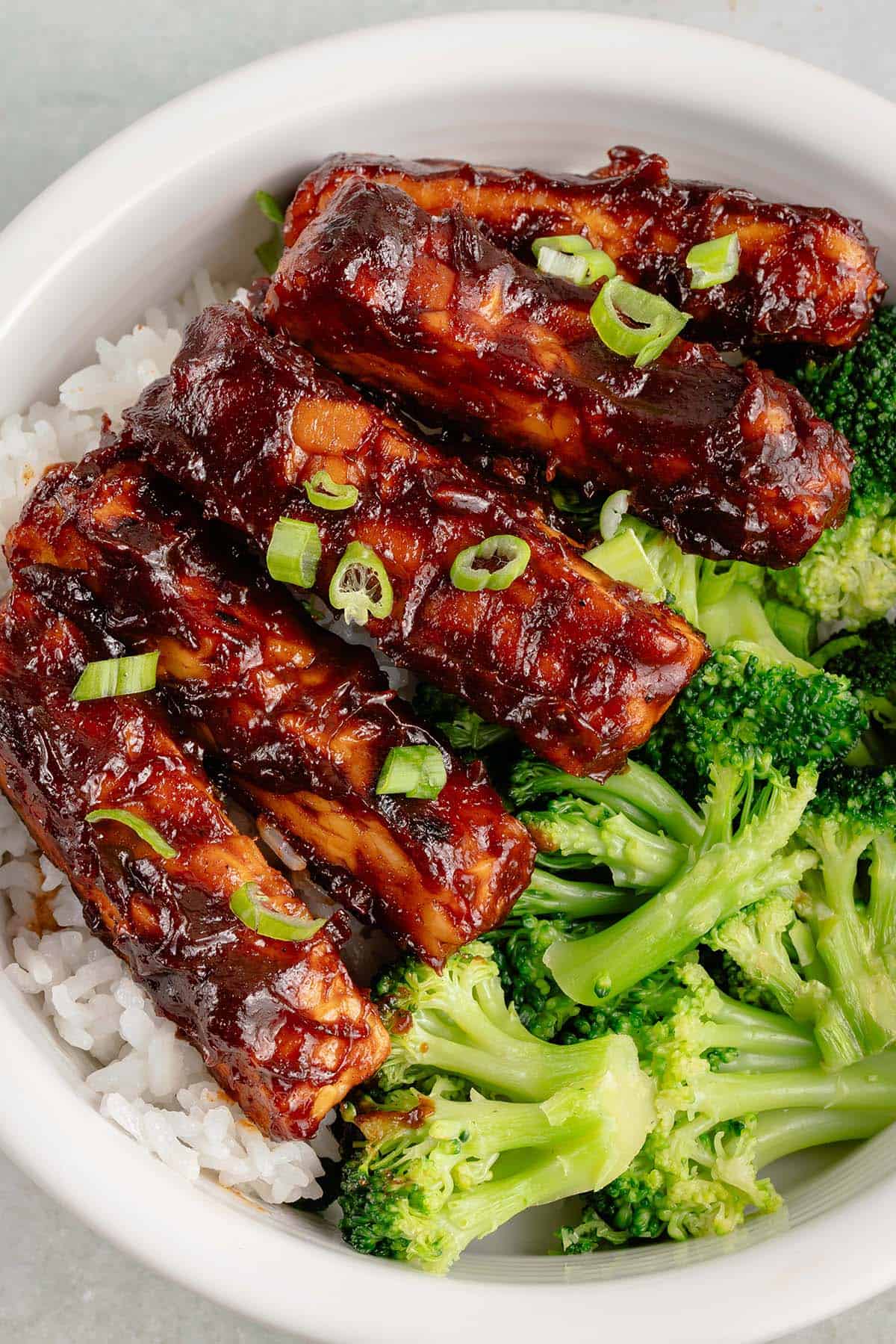 strips of barbecue tempeh with broccoli and rice in white bowl