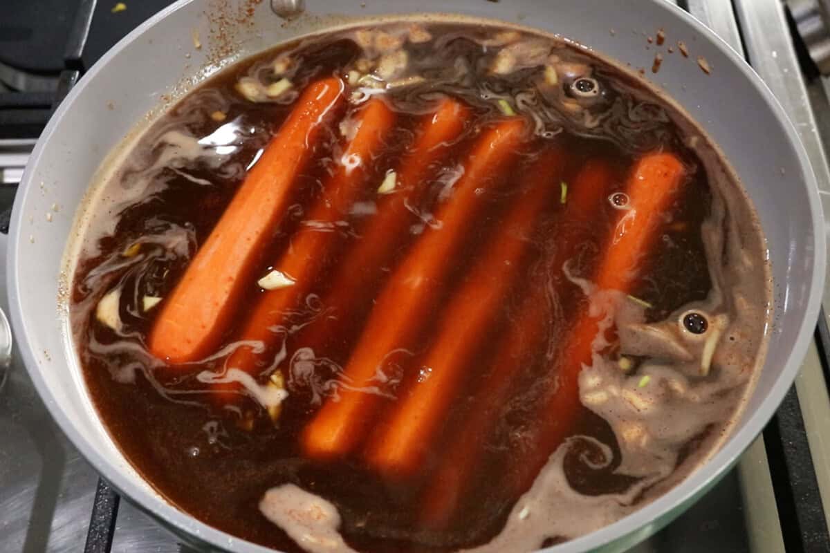 boiling peeled carrots in marinade for vegan carrot hot dogs