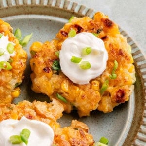 vegan corn fritters on blue plate with mayo and scallions