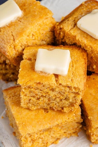 overhead image of cornbread squares with butter on top