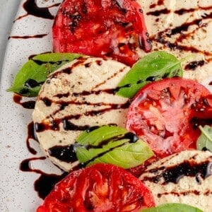 vegan mozzarella cheese with tomatoes and basil and a balsamic drizzle