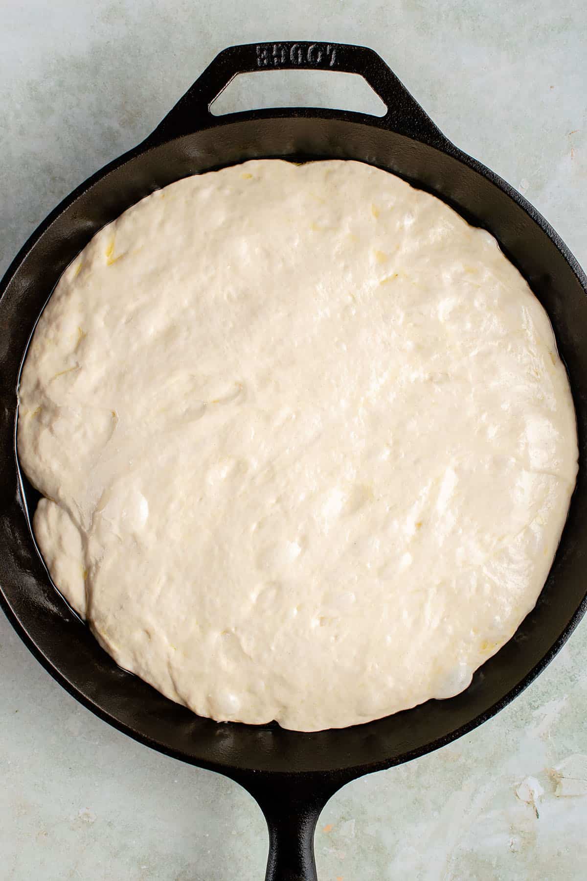 risen focaccia dough in skillet