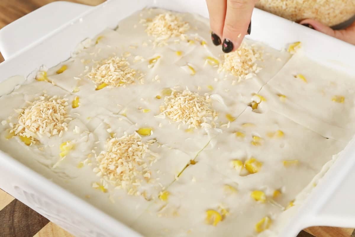 sprinkling coconut onto the maja blanca slices