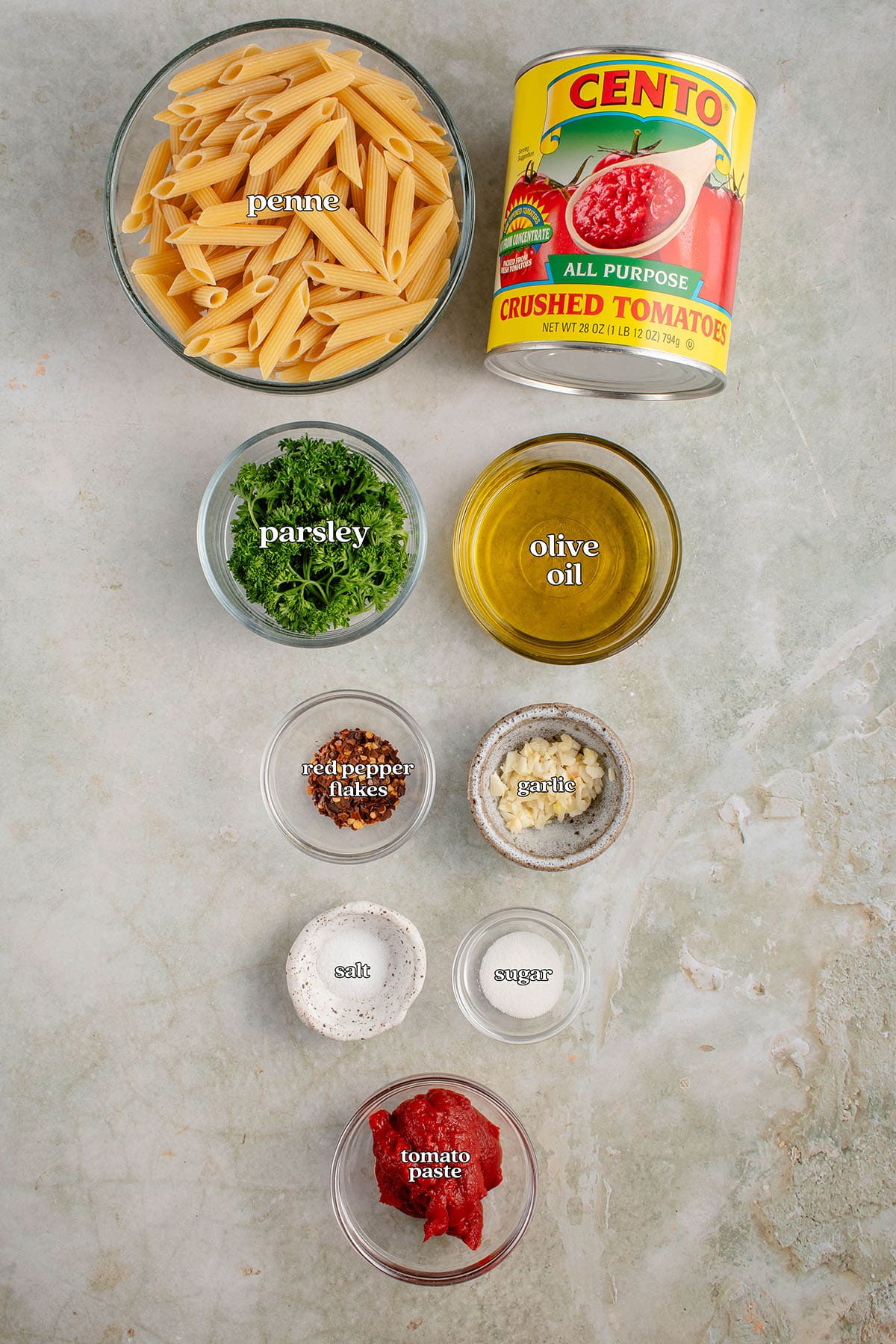 labeled ingredients for Penne All'Arrabbiata (Spicy Tomato Pasta): penne, olive oil, garlic, red pepper flakes, tomato paste, crushed tomatoes, sugar, salt and Fresh parsley