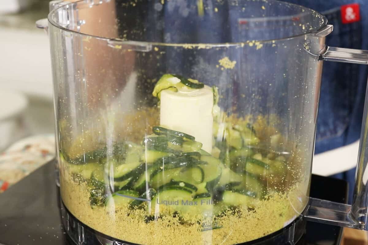 adding cooked zucchini to the food processor