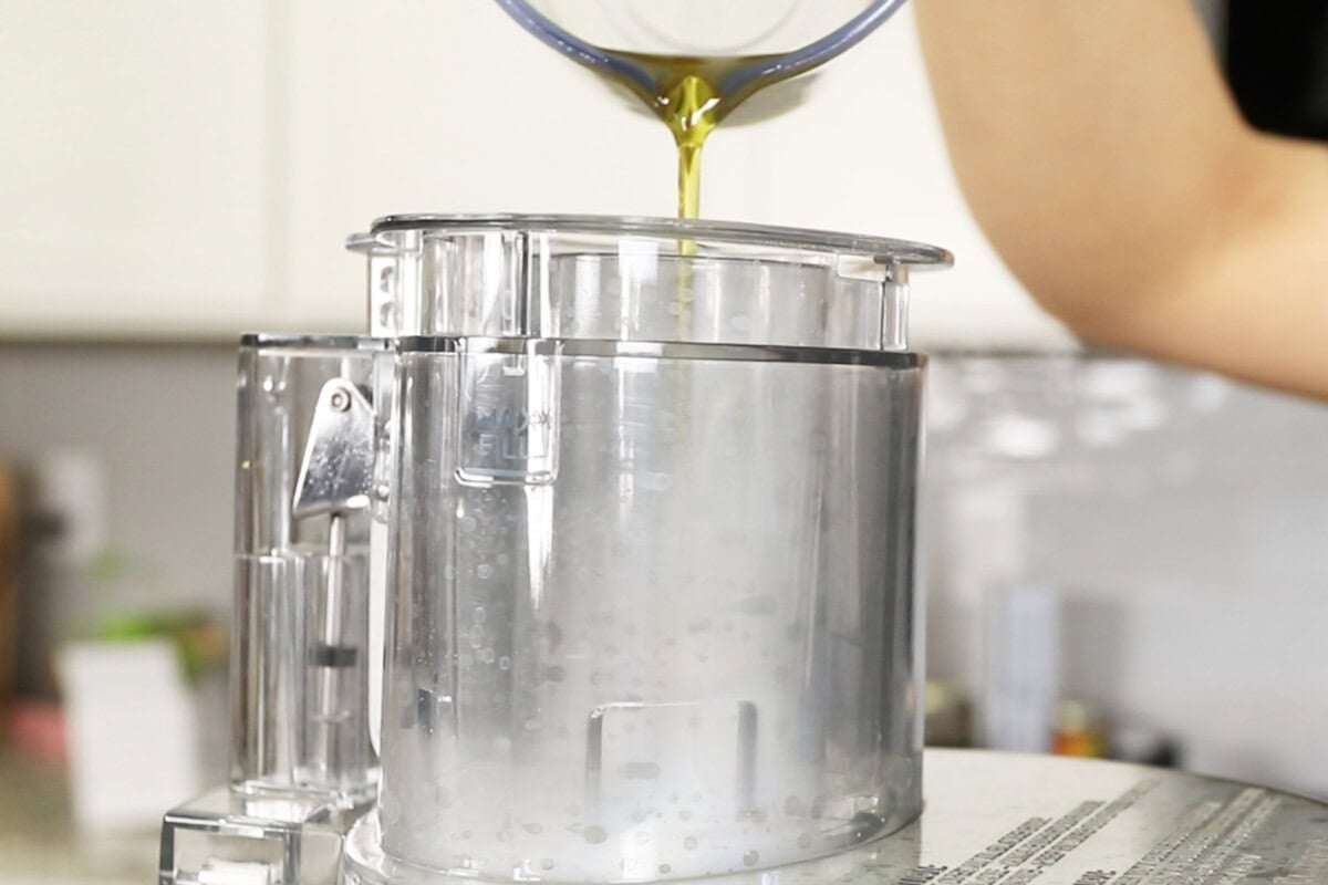 drizzling olive oil into a food processor