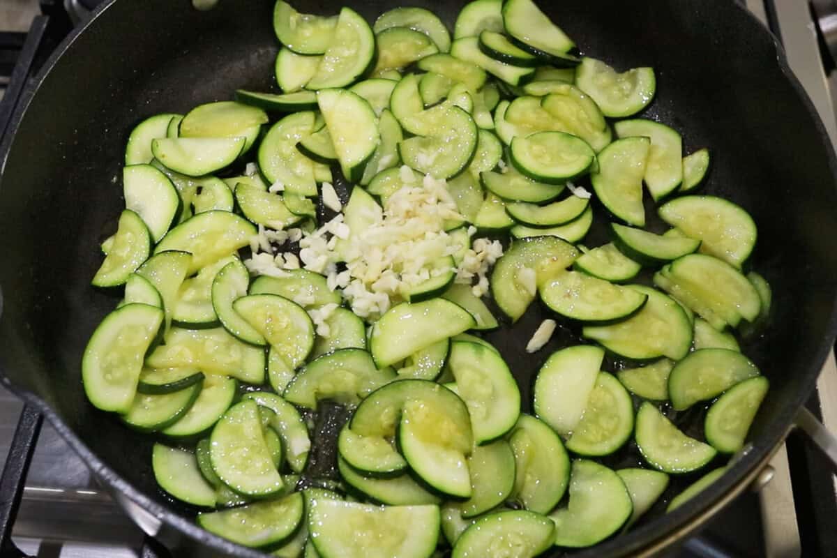 adding garlic to the cooked zucchini