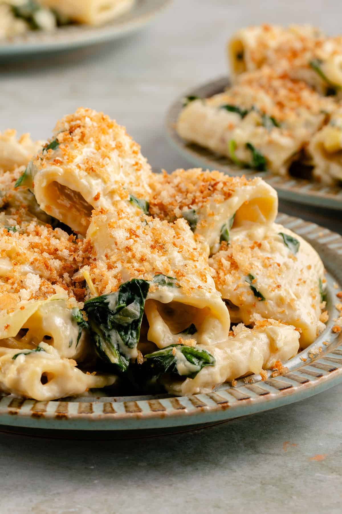 three plates of spinach artichoke pasta