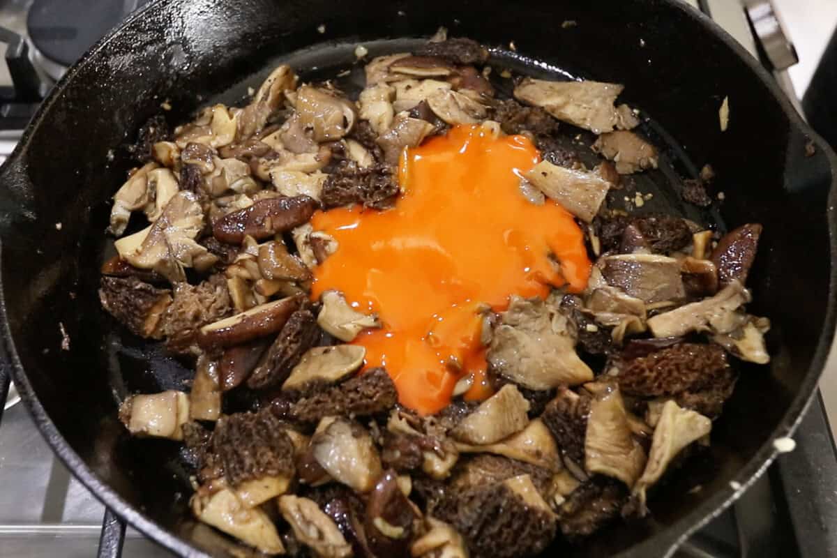 step by step: adding buffalo sauce to the pan of mushrooms