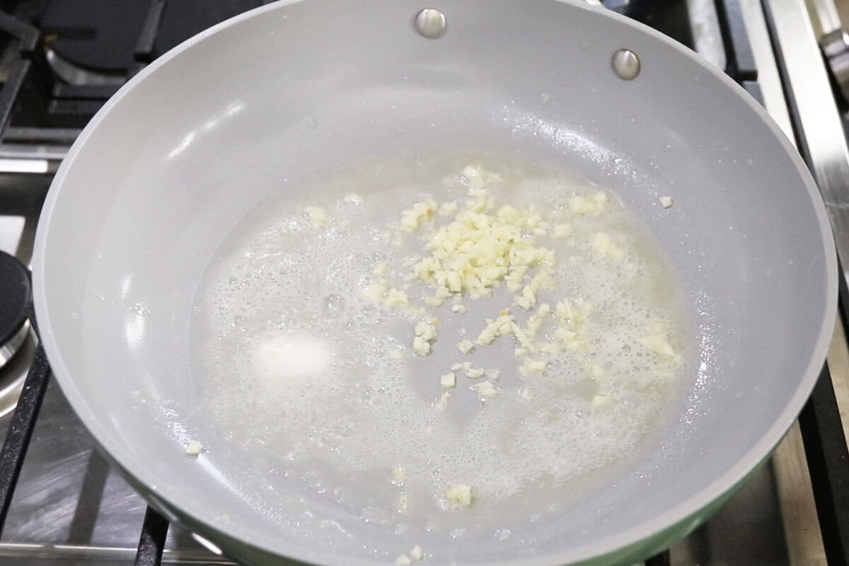 melted non-dairy butter and garlic in a nonstick caraway pan for Vegan Spinach Artichoke Pasta