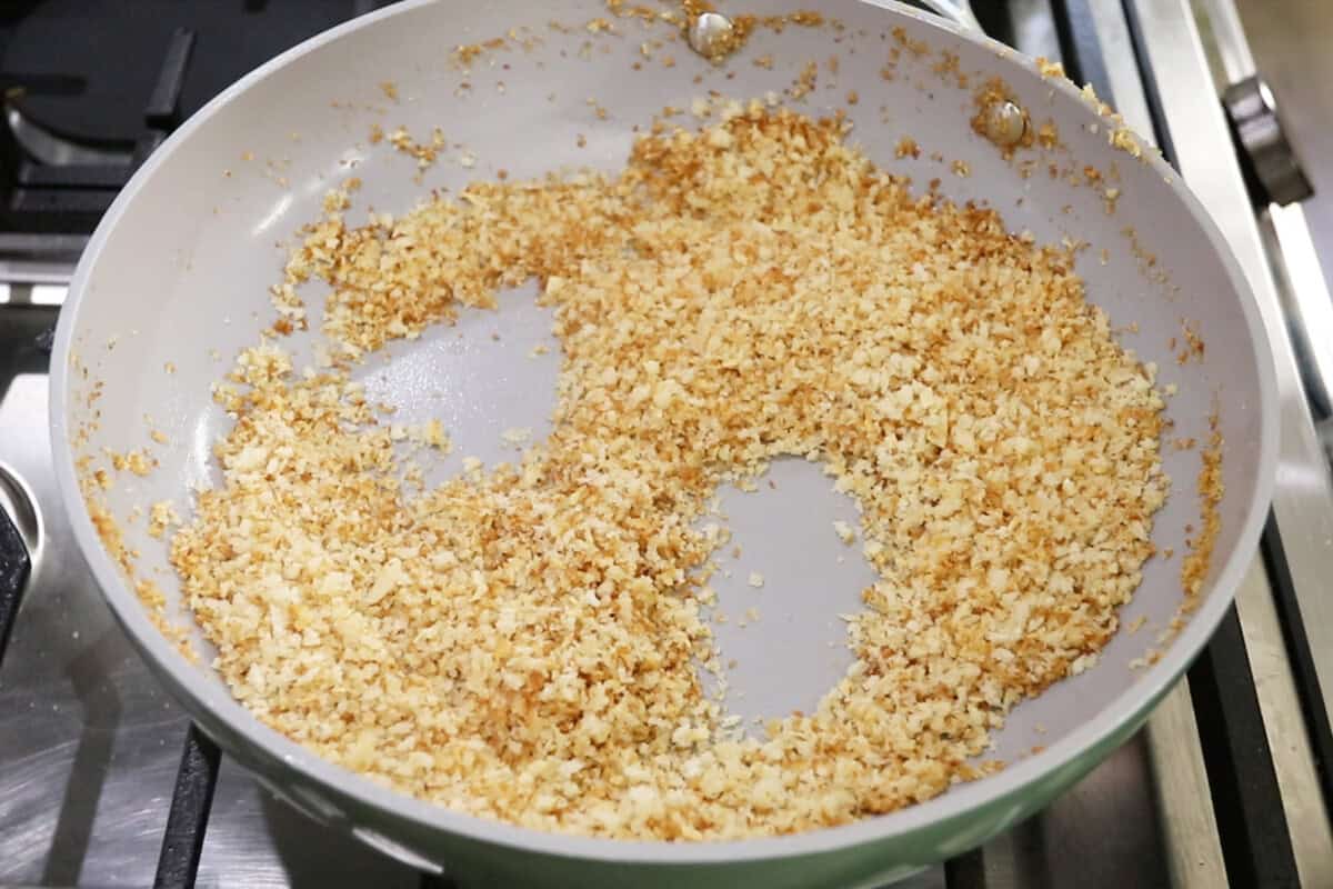 making garlic breafdrumbs in a nonstick caraway pan for Vegan Spinach Artichoke Pasta