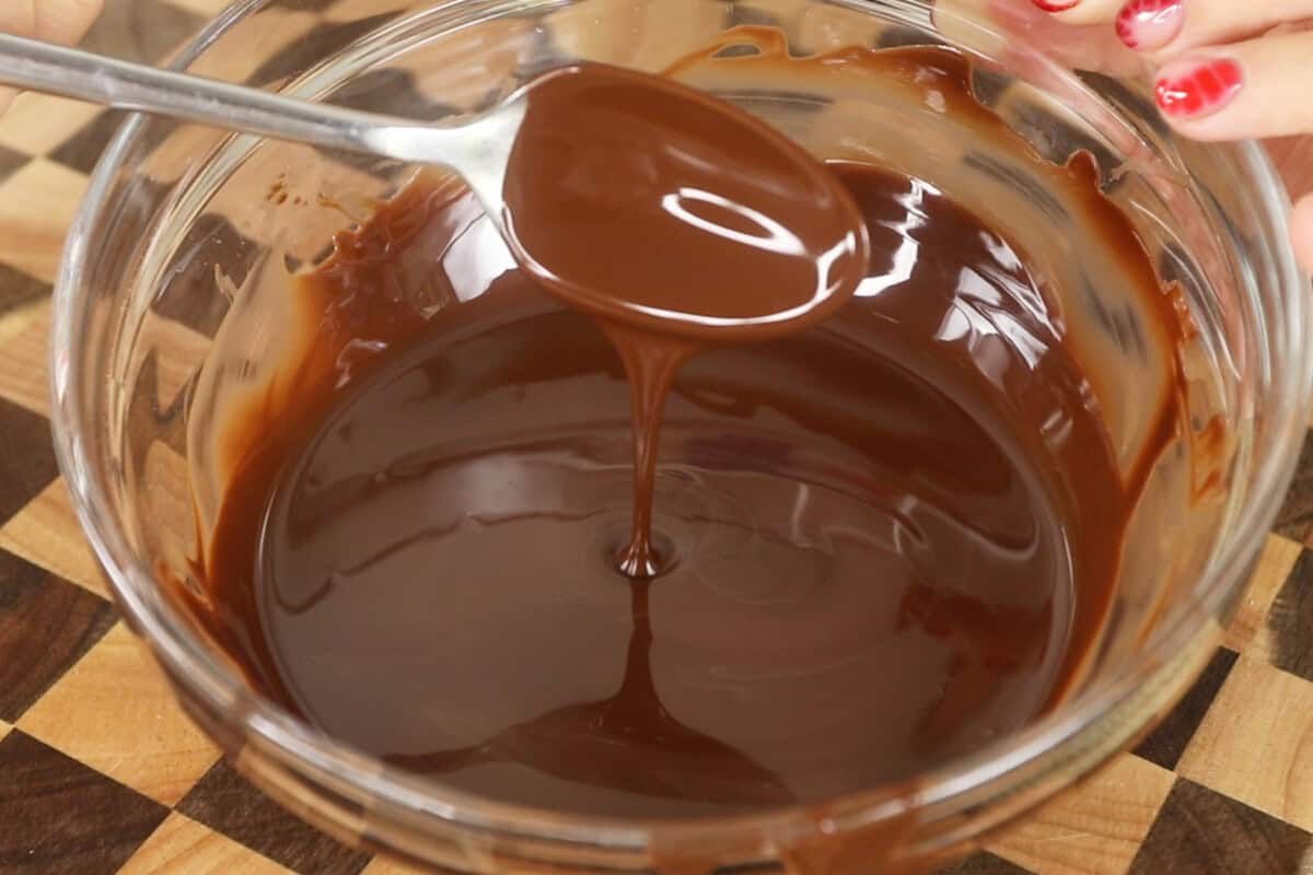 spooning melted chocolate in a bowl