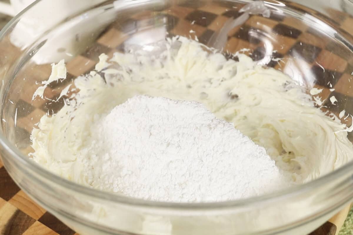 adding powdered sugar to a bowl