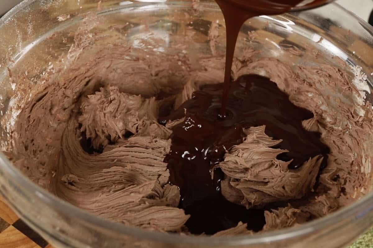 adding melted chocolate to the bowl