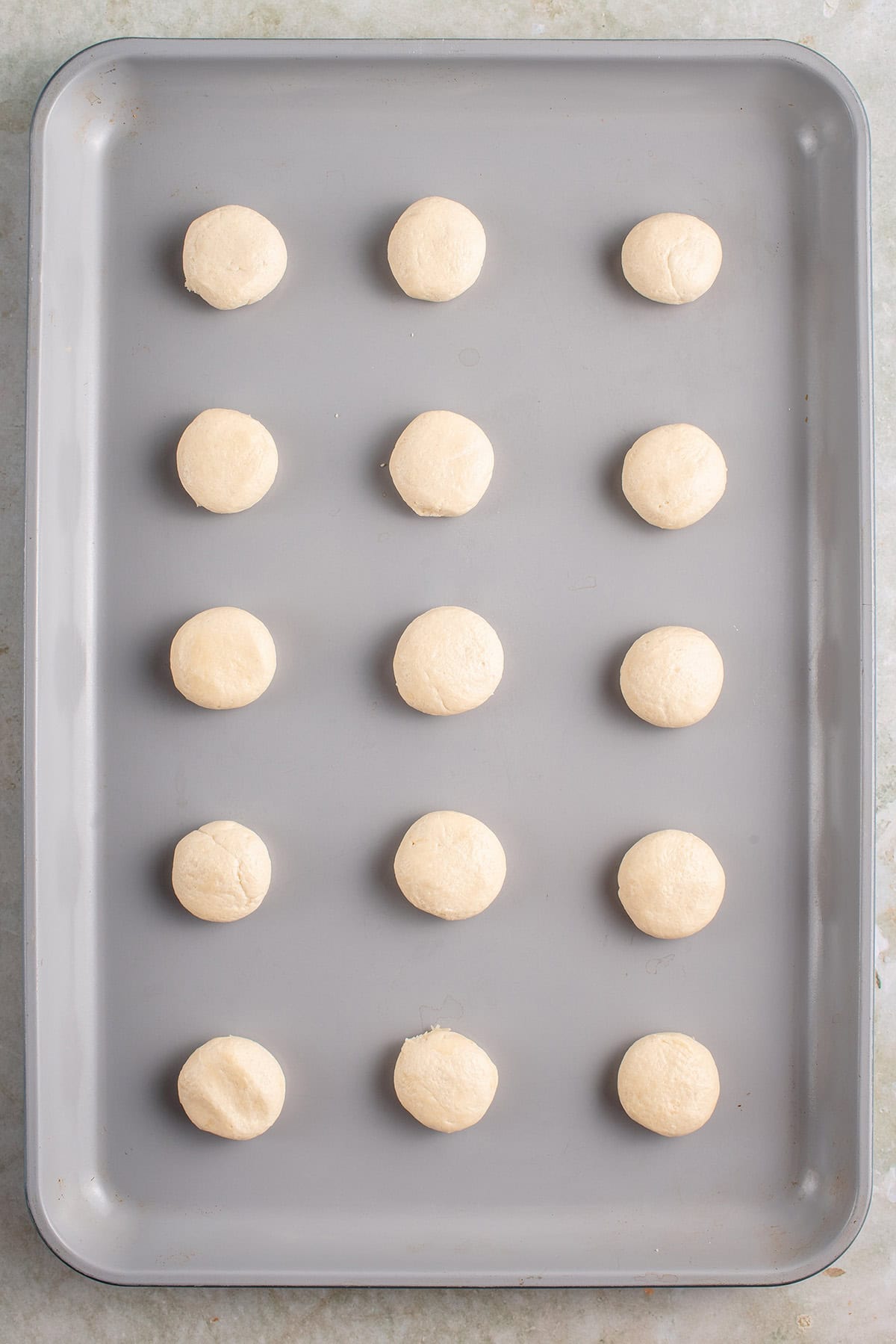 balls of cookie dough on a baking sheet before being baked