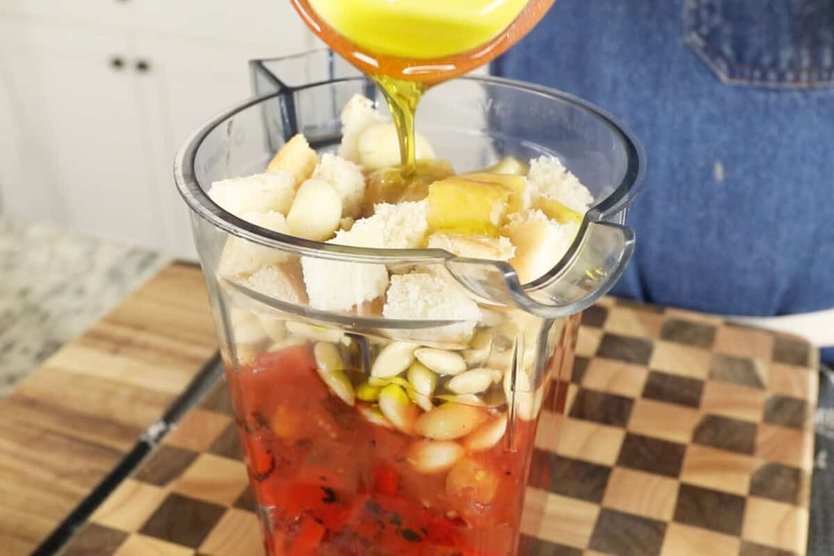 pouring romesco ingredients into a blender