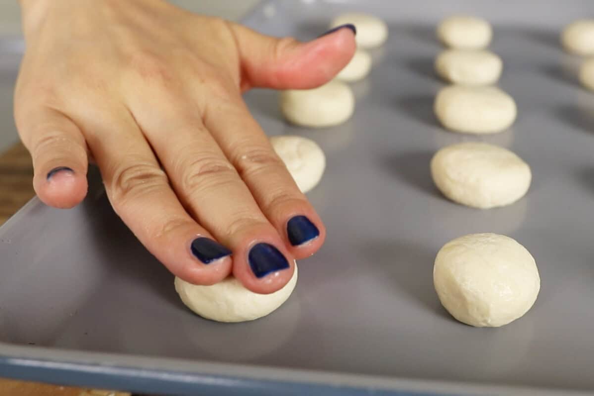 step by step: pressing down cookies on a baking sheet