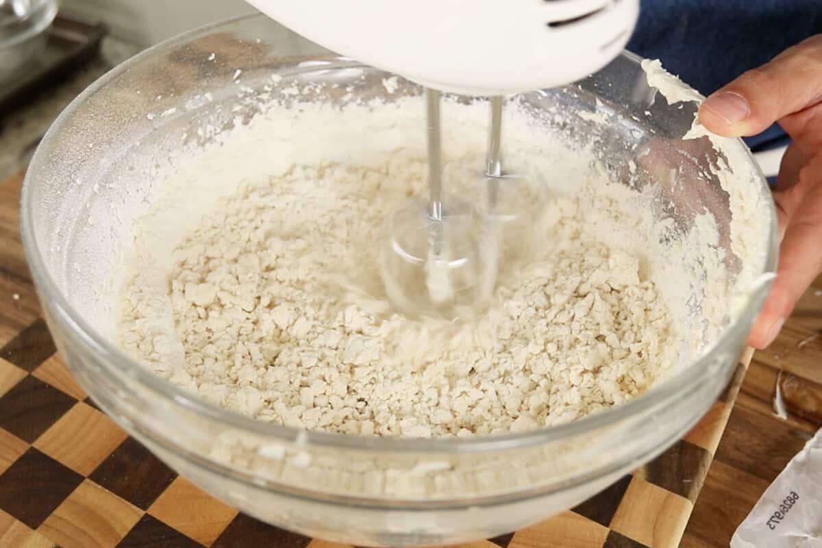 step by step: using a hand mixer to combine the flour with the butter and sugar