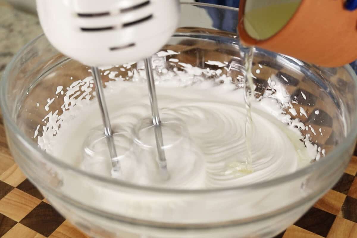 step by step: drizzling oil into the aquafaba mixture as it's beign mixed with a hand mixer