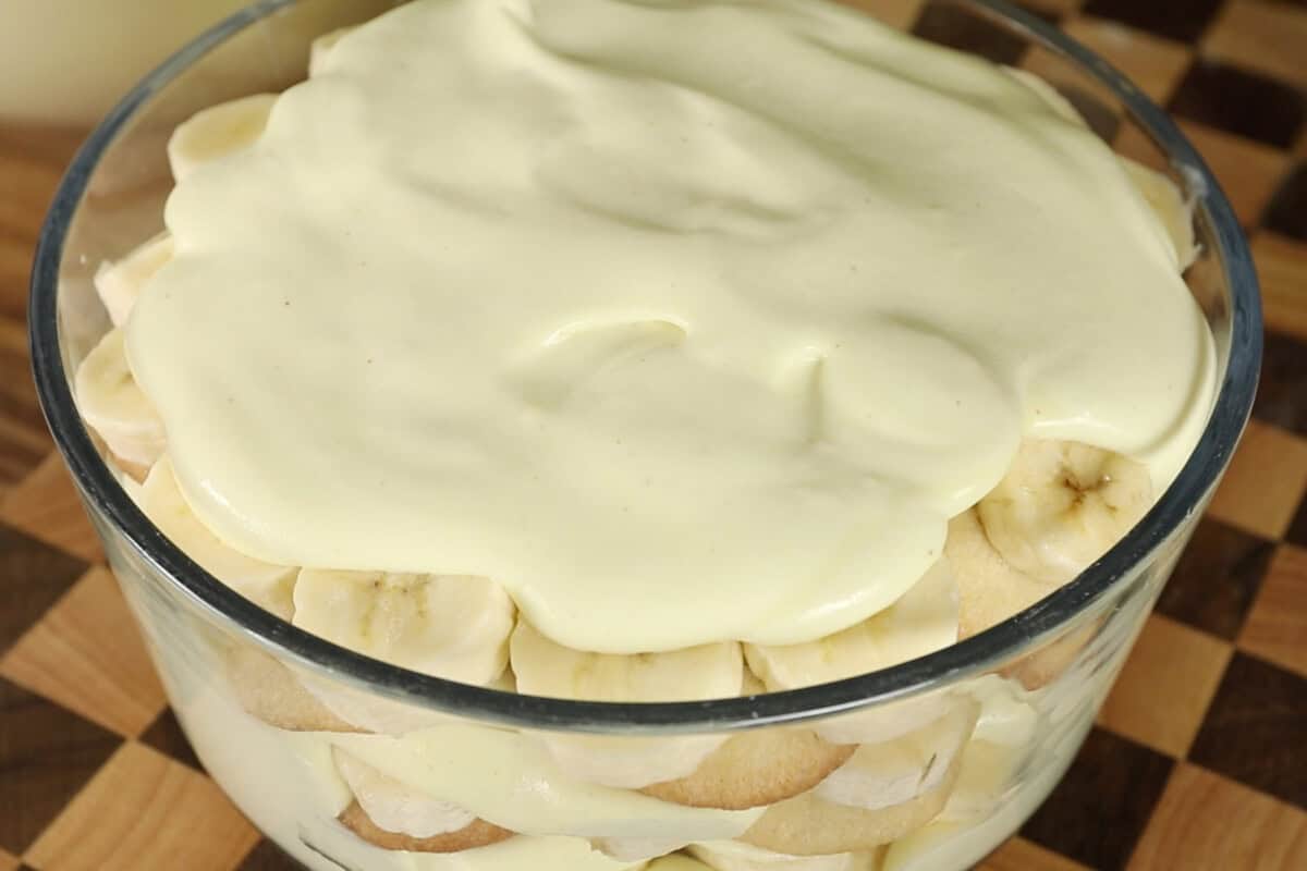 vegan banana pudding with whipped cream in clear trifle dish