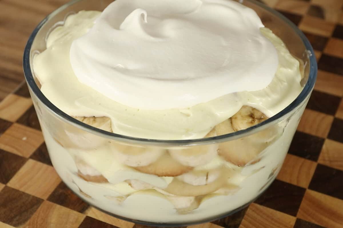 vegan banana pudding with whipped cream in clear trifle dish