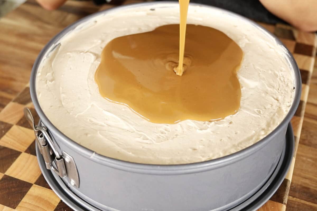 step by step: pouring melted cookie butter over set cheesecake