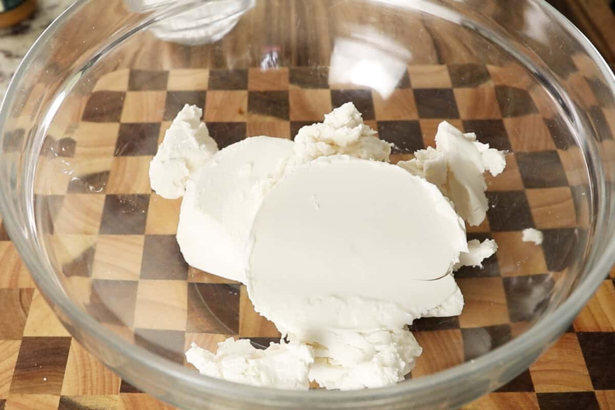 adding cream cheese to a bowl