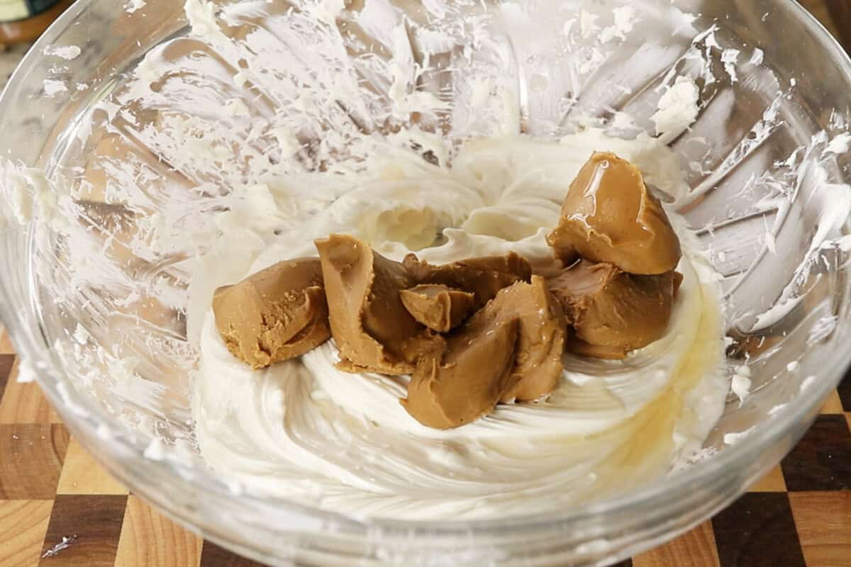 adding cookie butter to a large glass bowl