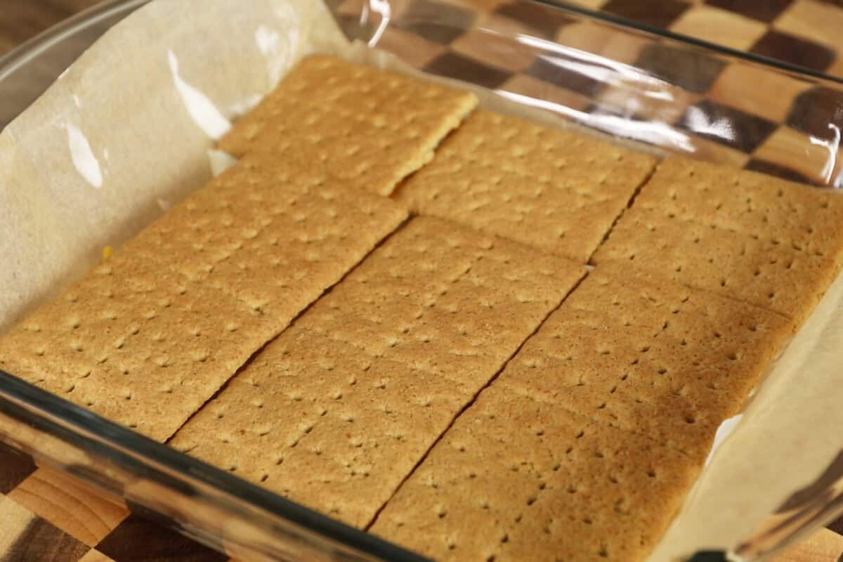 adding graham cracker layer into baking dish